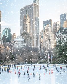 people skating on an ice rink in the middle of a large city with tall buildings