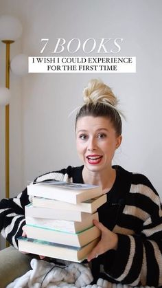 a woman sitting on a couch holding a stack of books with the title 7 books which could experience for the first time