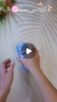 two hands are using a sponge to clean the surface of a table with flowers on it