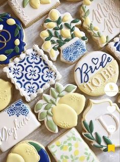 some decorated cookies are on a table with blue and yellow designs in the shape of lemons