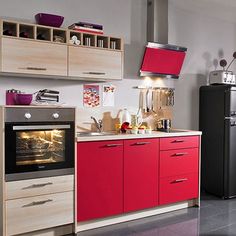 a kitchen with red and black cabinets, an oven and refrigerator in the center is shown