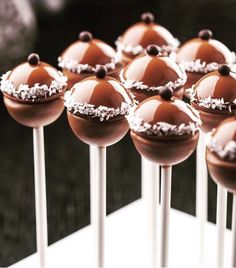 there are many chocolate covered cake pops on the table