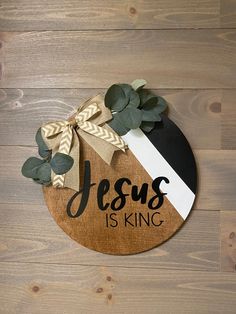 a wooden plaque with the words jesus is king and a bow on it that says jesus is king