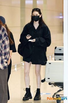 a woman wearing a face mask while walking through an airport