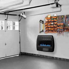 a garage with a fire place and tools hanging on the wall