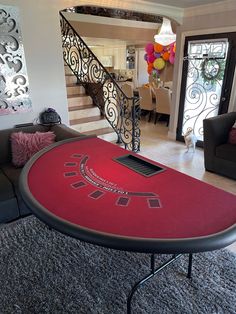 a table with a red cloth on it in front of a stair case and couch