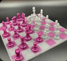 a pink and silver chess board with pieces on it