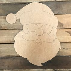 a cardboard cut out of santa claus on a wooden background