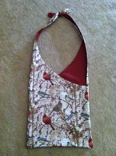 a small bag with birds on it laying on the ground next to a carpeted floor