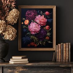 there is a painting on the wall next to some books and vase with flowers in it