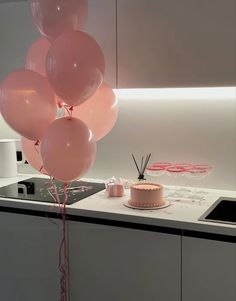 a cake and balloons on a kitchen counter