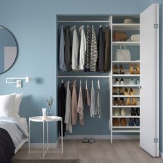 a bedroom with blue walls and white closets filled with clothes, shoes and handbags