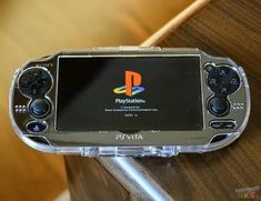 a close up of a nintendo wii game system on a wooden table with the logo for playstation