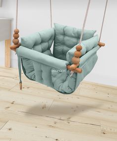 a blue swing chair with wooden legs on a wood floor