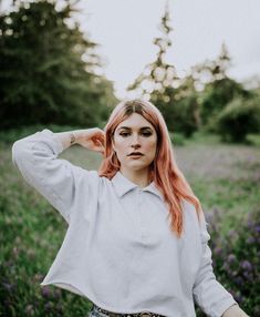 a woman with red hair standing in a field