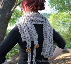 a woman with red hair is wearing a crocheted scarf and has her hands on her hips