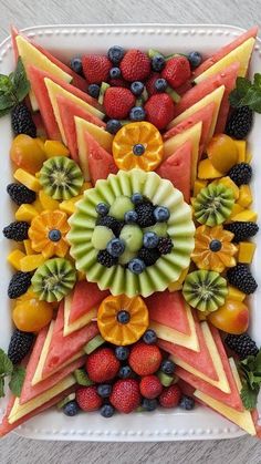 a white plate topped with sliced fruit and star shaped arrangement on top of each other