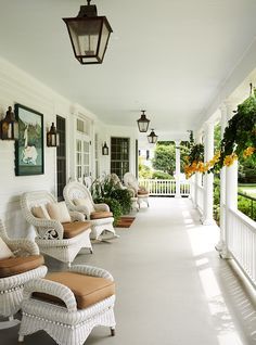 the front porch is lined with wicker chairs