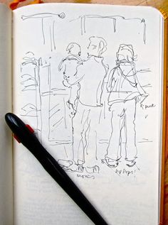 an open book with a drawing of people on it and a pen next to it