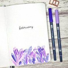 an open notebook with the word february written in cursive ink next to two pencils