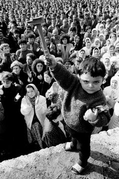 a crowd of people watching a young boy on a skateboard