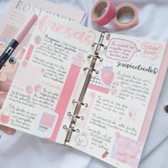 a person holding a pink pen and writing on a page in a notebook with sticky notes