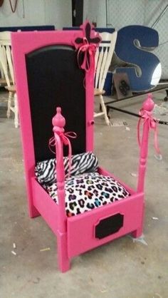 a pink and black bed frame with leopard print pillows on the bottom, sitting in a garage