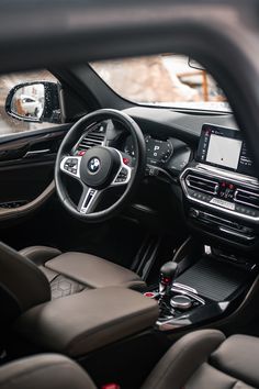 the interior of a bmw car with leather seats and dashboard, including an electronic display