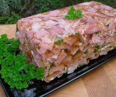 a piece of meat sitting on top of a black plate next to some parsley