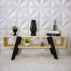 a wooden shelf with two black vases on top of it next to a white wall