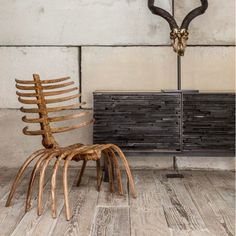 a wooden chair sitting next to a black cabinet on top of a hard wood floor