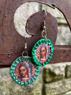 "I made these earrings with green bottle caps and images of the Virgen of Guadalupe.  They have fishhook style ear wires for pierced ears.  They are rustic and handmade.  Measures from top of the ear wire to the bottom about  1 3/4\". As is, no returns." Virgen Of Guadalupe, Bottle Cap Earrings, Green Bottle, Bottle Caps, Fish Hook, Pierced Ears, Bottle Cap, Dallas Tx, Ear Wire