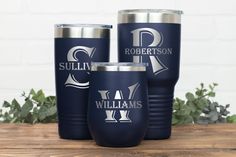 three personalized tumblers sitting on top of a wooden table