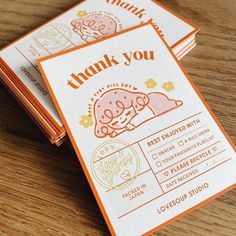 three thank you cards sitting on top of a wooden table next to an orange and white envelope