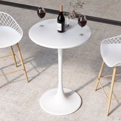 three white chairs and a table with two bottles of wine