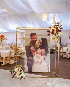 an image of a man and woman on a photo frame with flowers in front of them