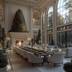 an elegant dining room with large windows and christmas trees in the fireplace mantels