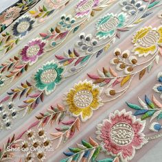 several different types of embroidered fabric with flowers and leaves on the side, all in pastel colors