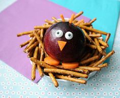 an apple sitting on top of a pile of french fries next to a bird's nest