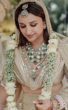 a woman wearing a bridal outfit and jewelry