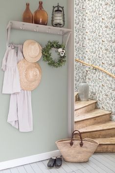 there is a shelf with hats and baskets on it next to the stairs in this room