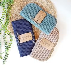 three blue and white towels sitting next to each other on top of a straw hat