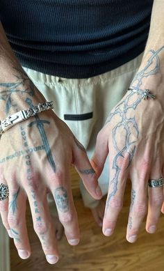 two men with tattoos on their hands holding onto each other's wrists and fingers