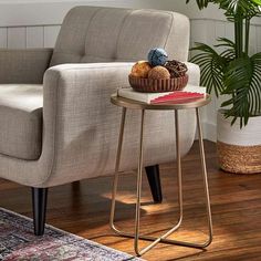 a living room with a chair, table and potted plant on the floor next to it