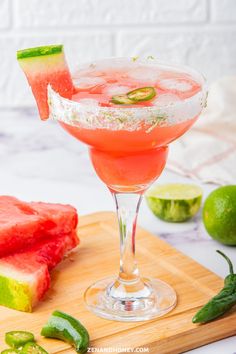 a watermelon margarita sitting on top of a wooden cutting board