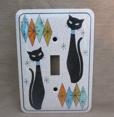 a light switch cover with black cats on it