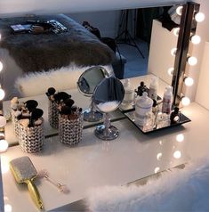 a vanity with lights and makeup on it