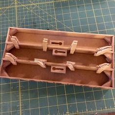 three pieces of wood sitting on top of a green cutting mat with scissors and tape