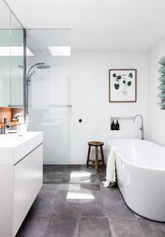 a white bath tub sitting in a bathroom next to a walk in shower and sink