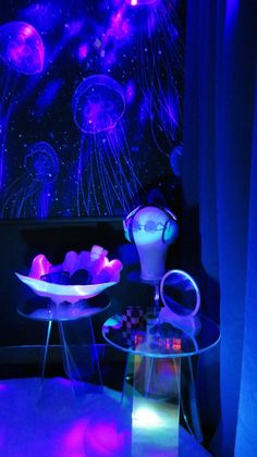 a room with jellyfish in the ceiling and blue lighting on the walls, along with two glass tables